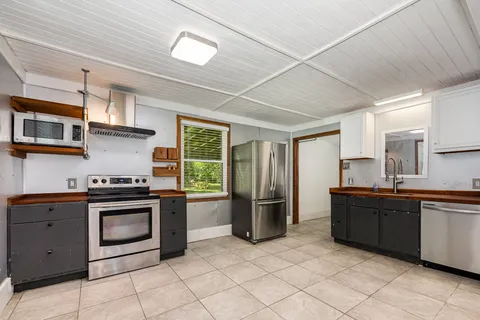 a kitchen with stainless steel appliances granite countertop a stove sink and cabinets