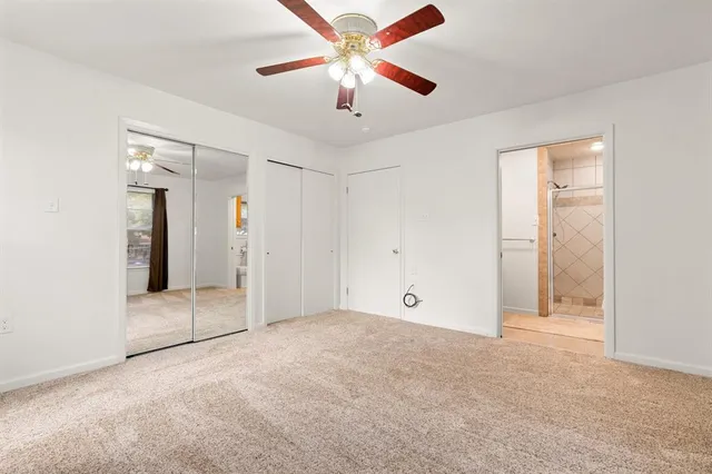 an empty room with fan and entryway