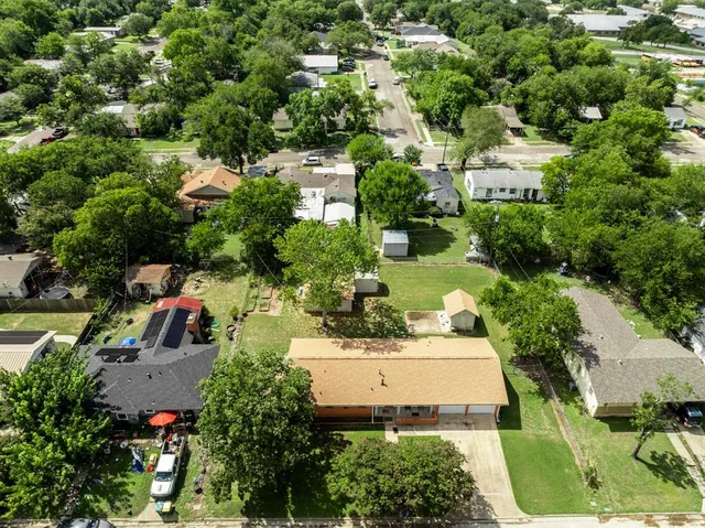 an aerial view of residential house with outdoor space and trees all around