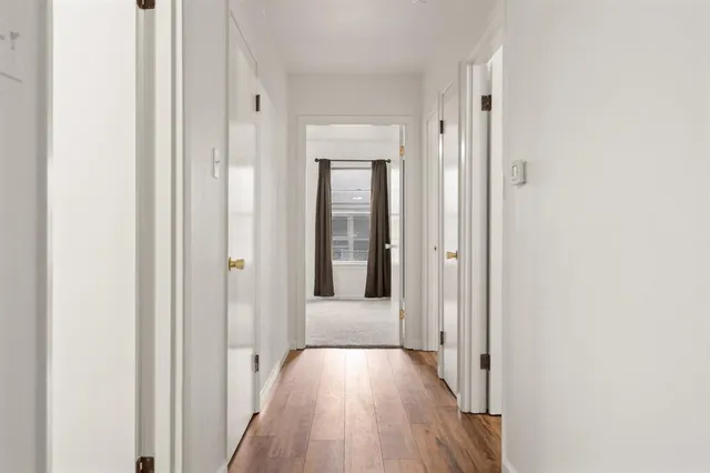 a view of a hallway with wooden floor
