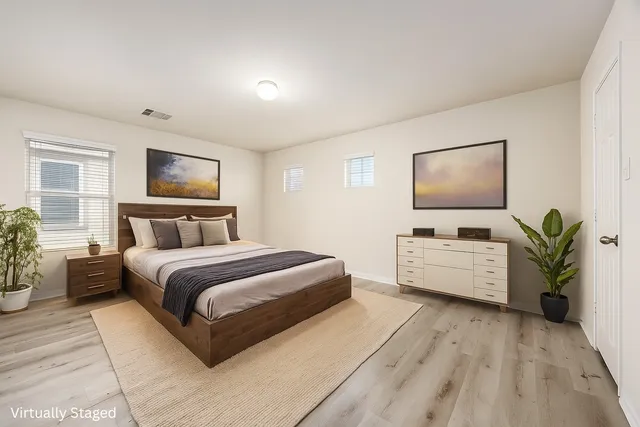 a spacious bedroom with a bed and a flat screen tv