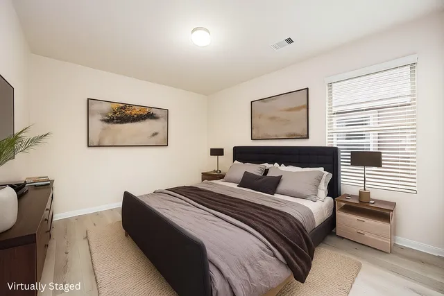 a bedroom with bed and paintings on the wall