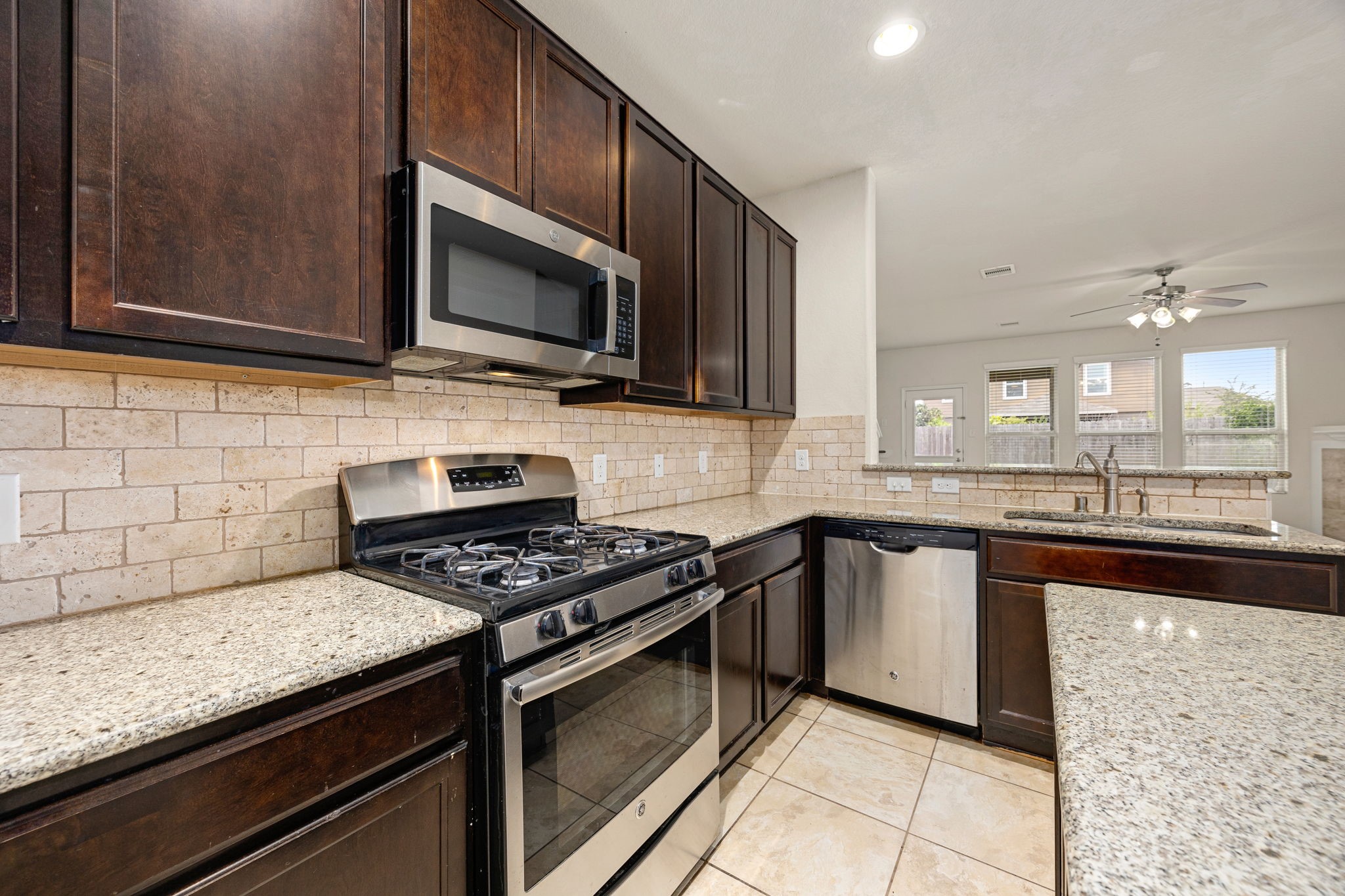 29322 Indian Clearing Spring, TX 77386 - Photo 18 of 41 a kitchen with stainless steel appliances granite countertop a stove microwave and sink