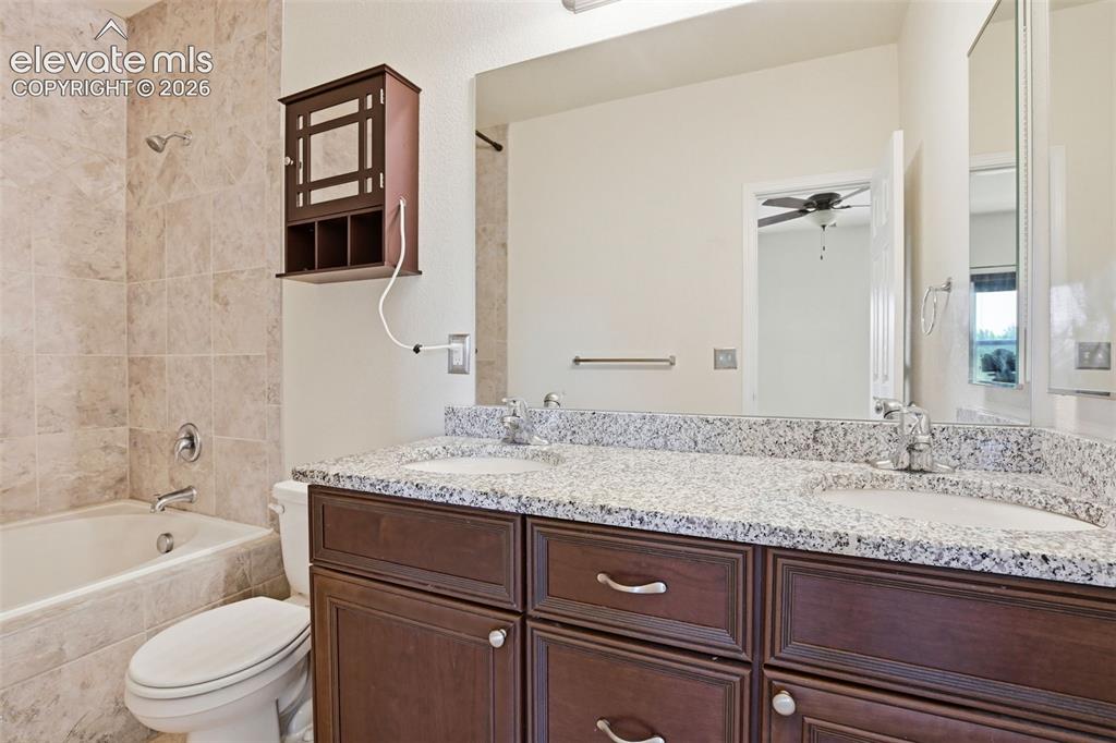 7806 Dutch Loop Colorado Springs, CO 80925 - Photo 15 of 41 a bathroom with a granite countertop sink a toilet and bathtub