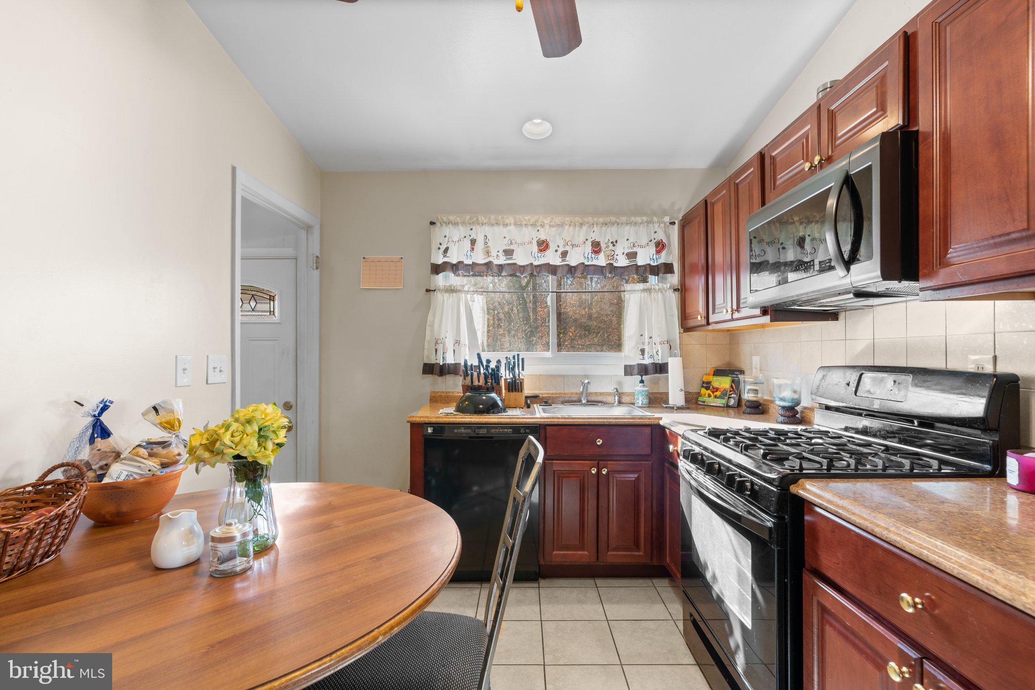 4727 Byron Road Windsor Mill, MD 21244 - Photo 13 of 35 a kitchen with stainless steel appliances granite countertop a stove a sink dishwasher and cabinets with wooden floor