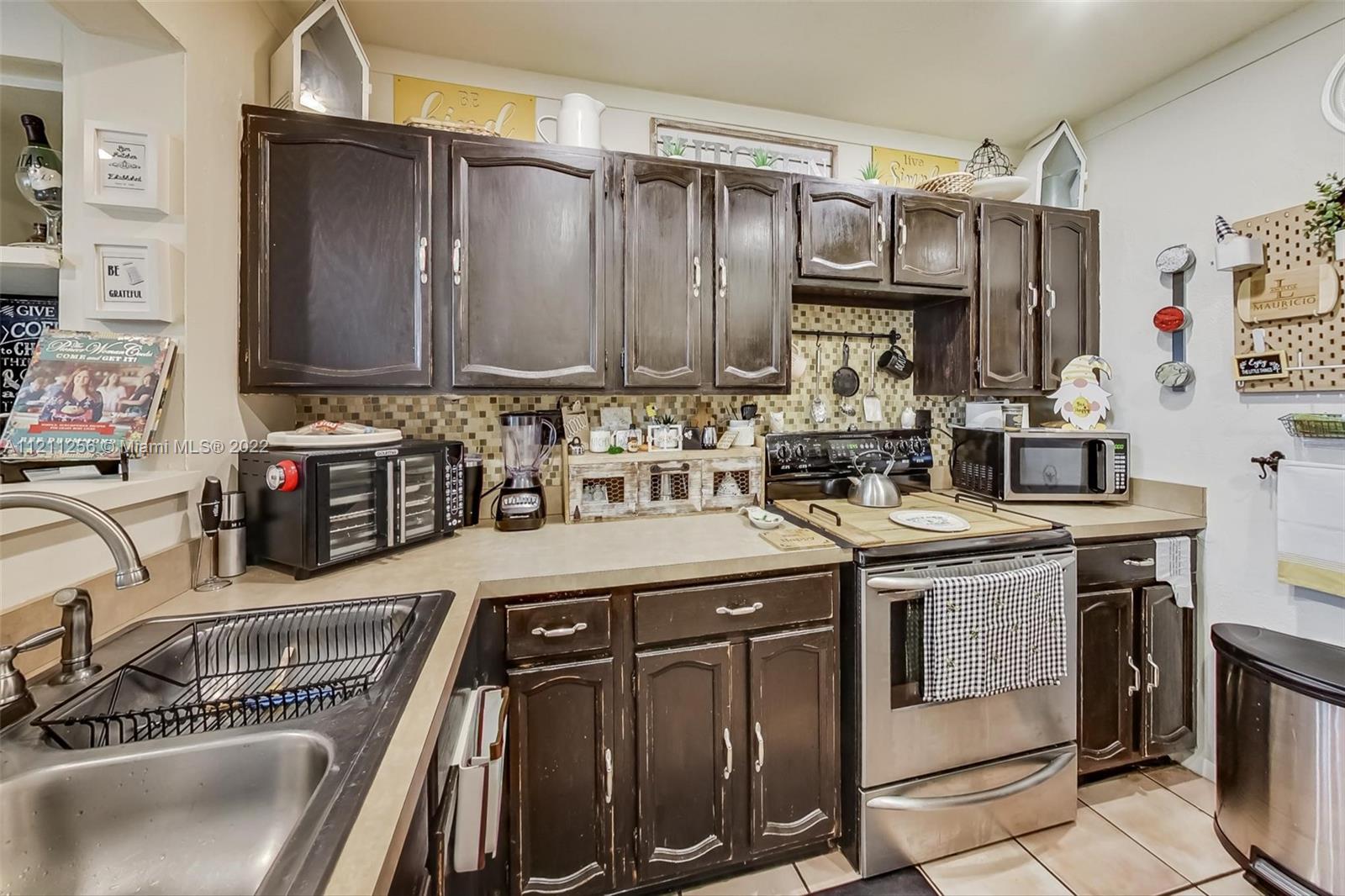 9345 Southwest 42nd Terrace Miami, FL 33165 - Photo 15 of 48 a kitchen with stainless steel appliances granite countertop a sink stove and cabinets