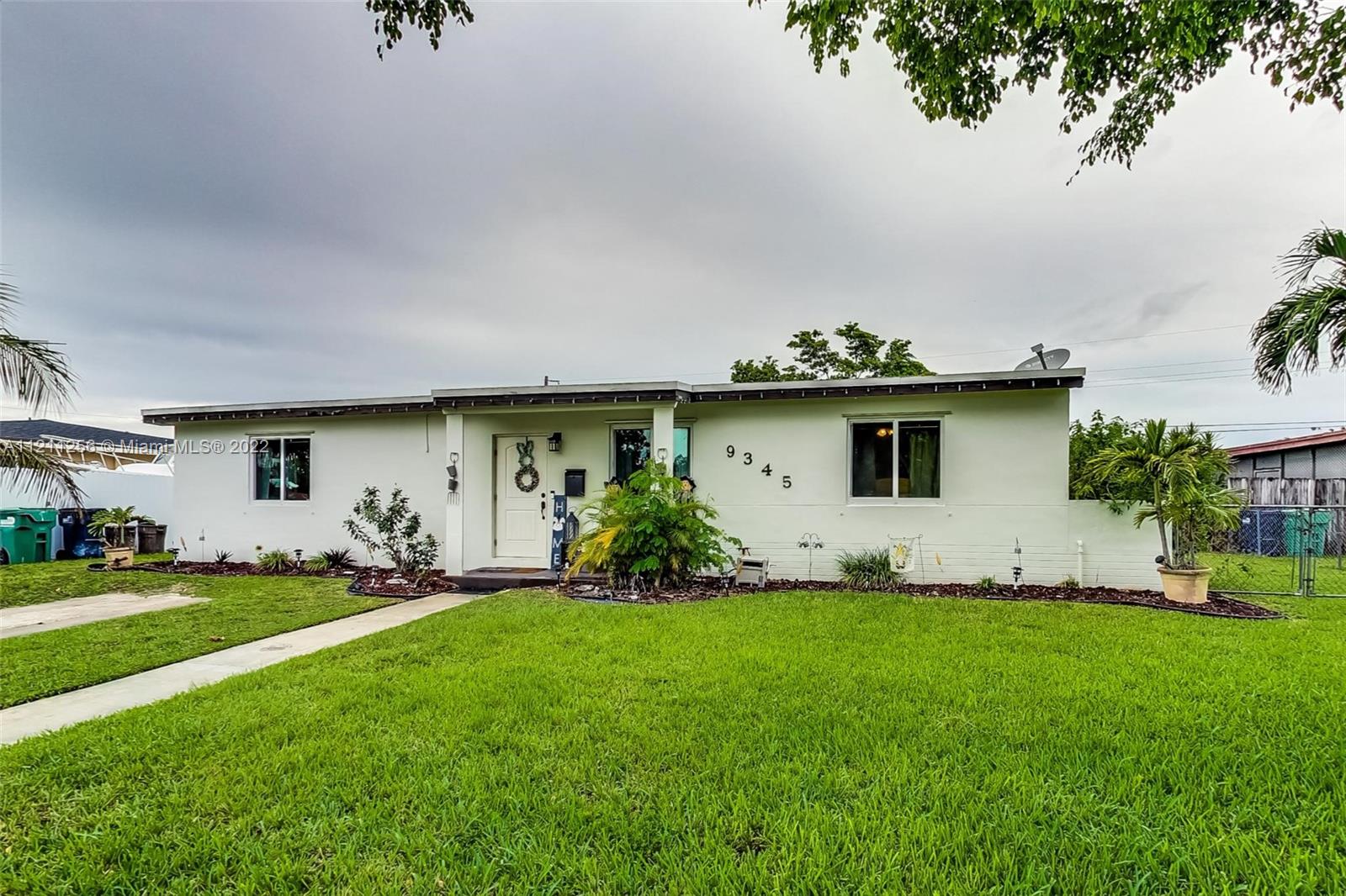 9345 Southwest 42nd Terrace Miami, FL 33165 - Photo 3 of 48 a view of a white house with a big yard and large trees