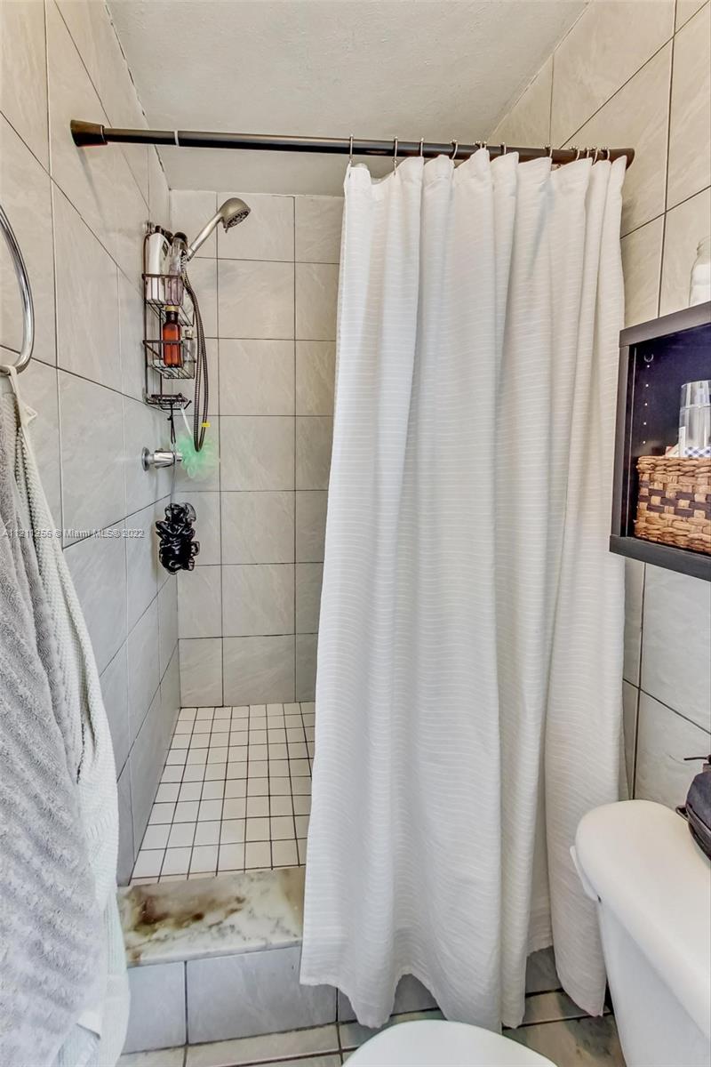 9345 Southwest 42nd Terrace Miami, FL 33165 - Photo 36 of 48 a bathroom with a shower curtain and sink