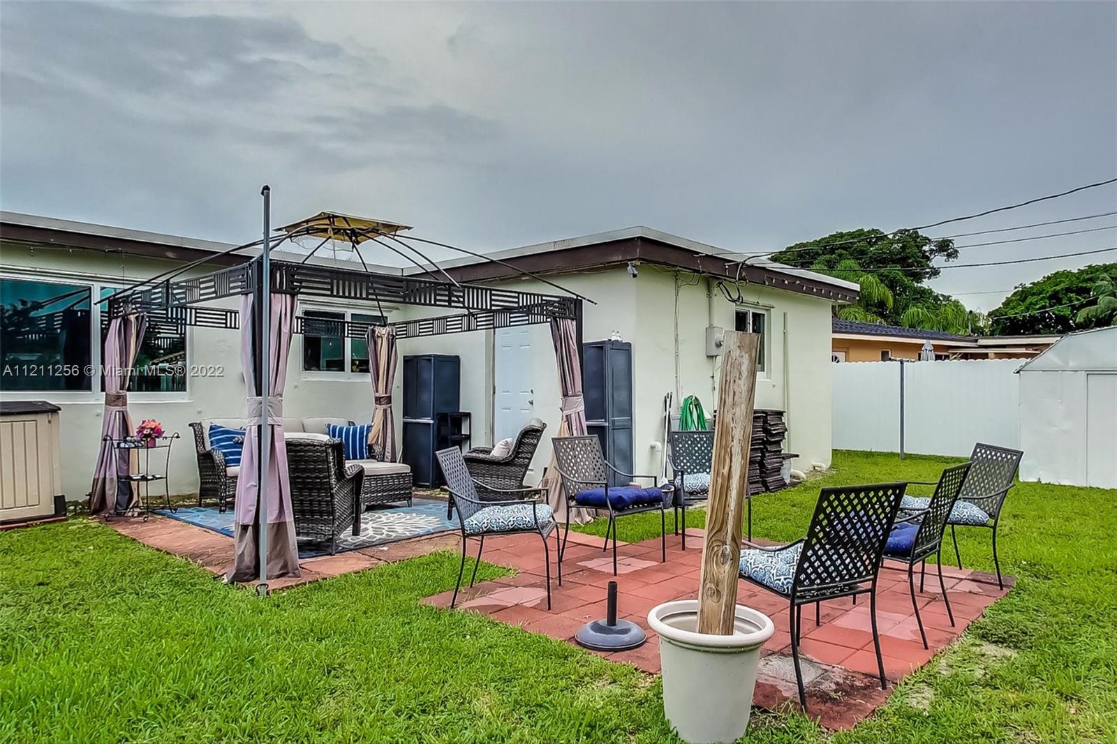 9345 Southwest 42nd Terrace Miami, FL 33165 - Photo 40 of 48 a view of a patio with a dining table and chairs and potted plants