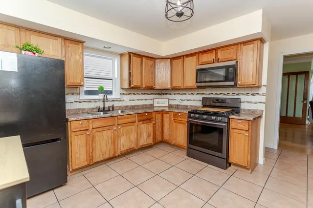 a kitchen with stainless steel appliances granite countertop a stove top oven a sink dishwasher and a refrigerator
