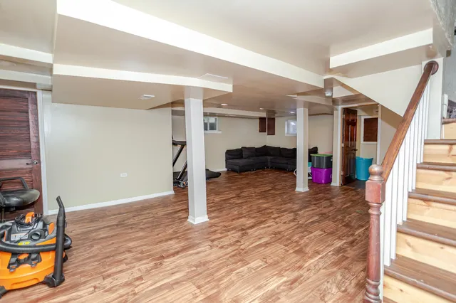 a view of a livingroom with wooden floor and staircase