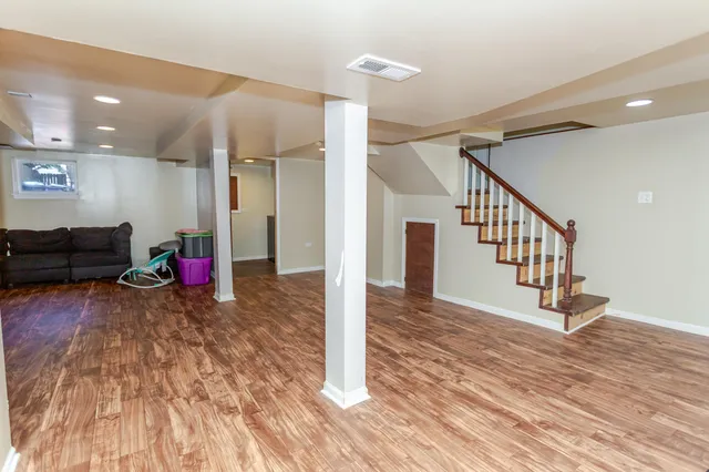 a view of a livingroom with wooden floor and staircase