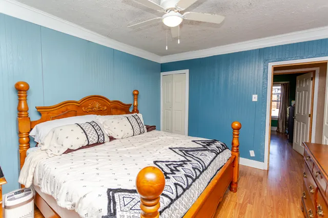 a bedroom with a bed and wooden floor
