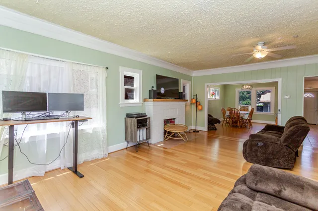 a living room with furniture a flat screen tv and a table