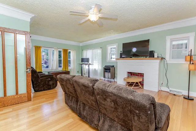 a living room with furniture a flat screen tv and a fireplace