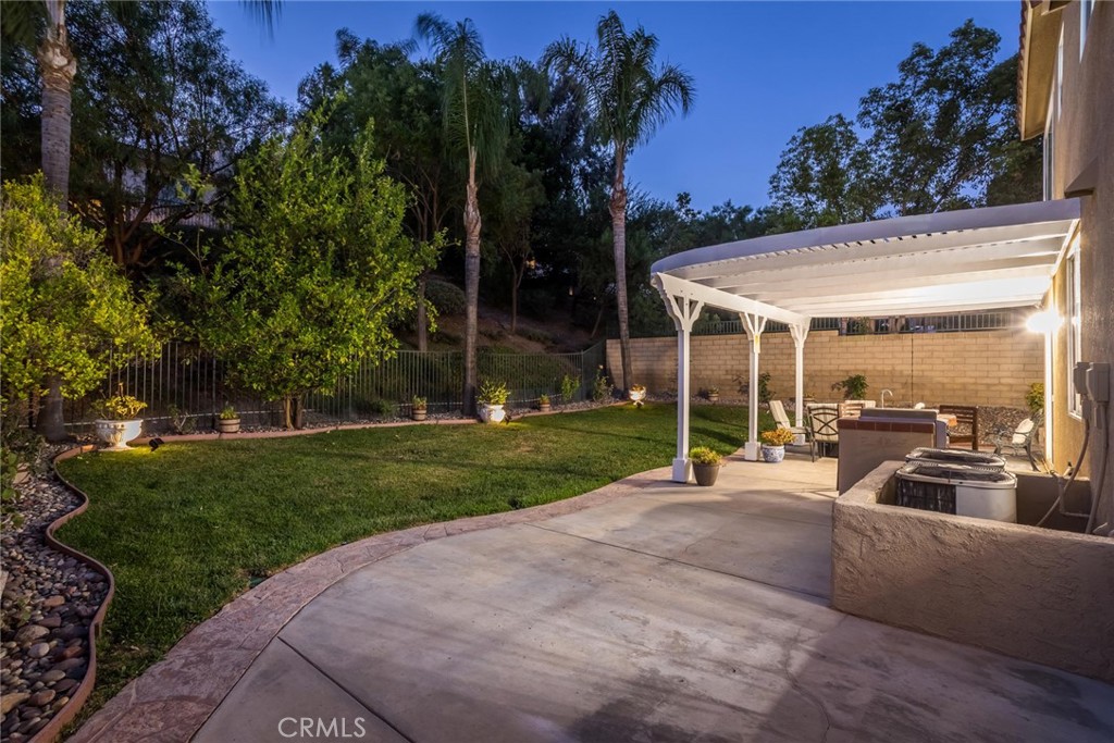25707 Lewis Way Stevenson Ranch, CA 91381 - Photo 32 of 35 a view of a backyard with couches under an umbrella