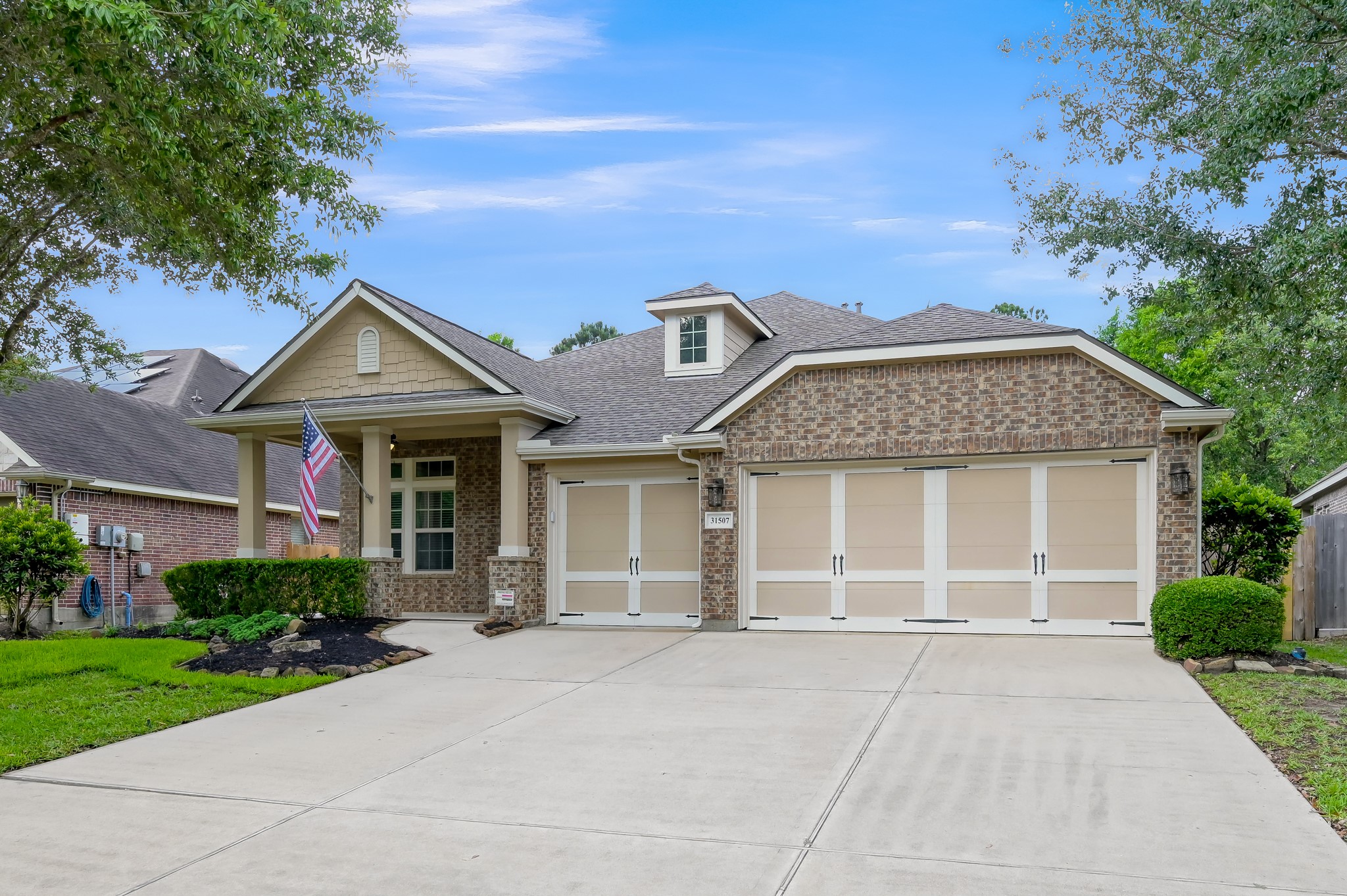 31507 Boulder Cliff Lane Spring, TX 77386 - Photo 2 of 45 This charming home features a brick façade with a well-maintained front yard and a spacious driveway leading to a three-car garage. The inviting porch adds a welcoming touch to the exterior.