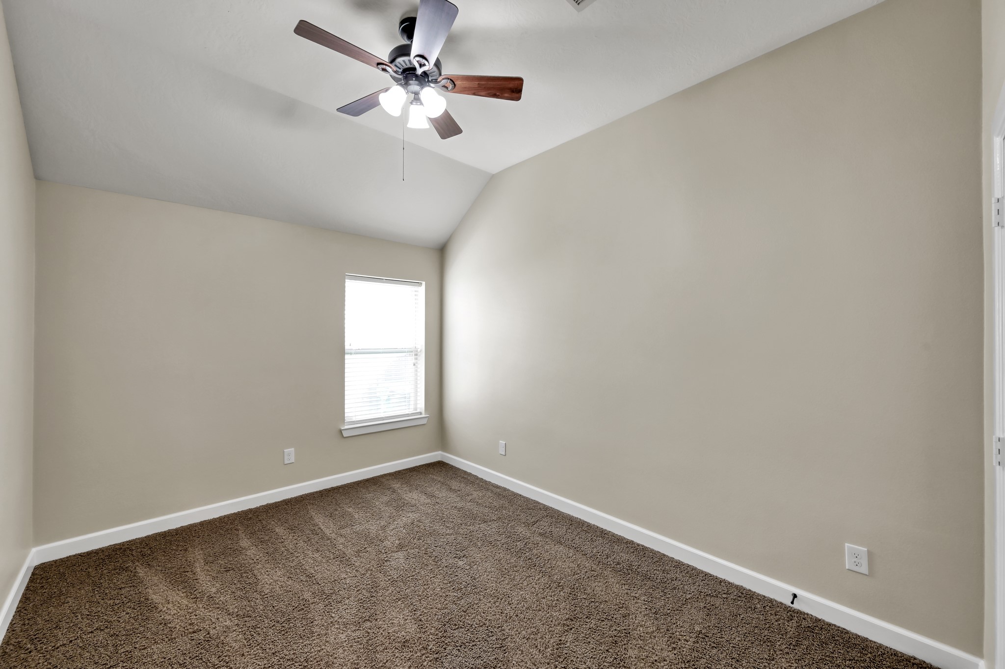 31507 Boulder Cliff Lane Spring, TX 77386 - Photo 31 of 45 This room features neutral walls, a carpeted floor, a ceiling fan with lighting, and a single window that provides natural light. It's a cozy, versatile space suitable for a bedroom or office.