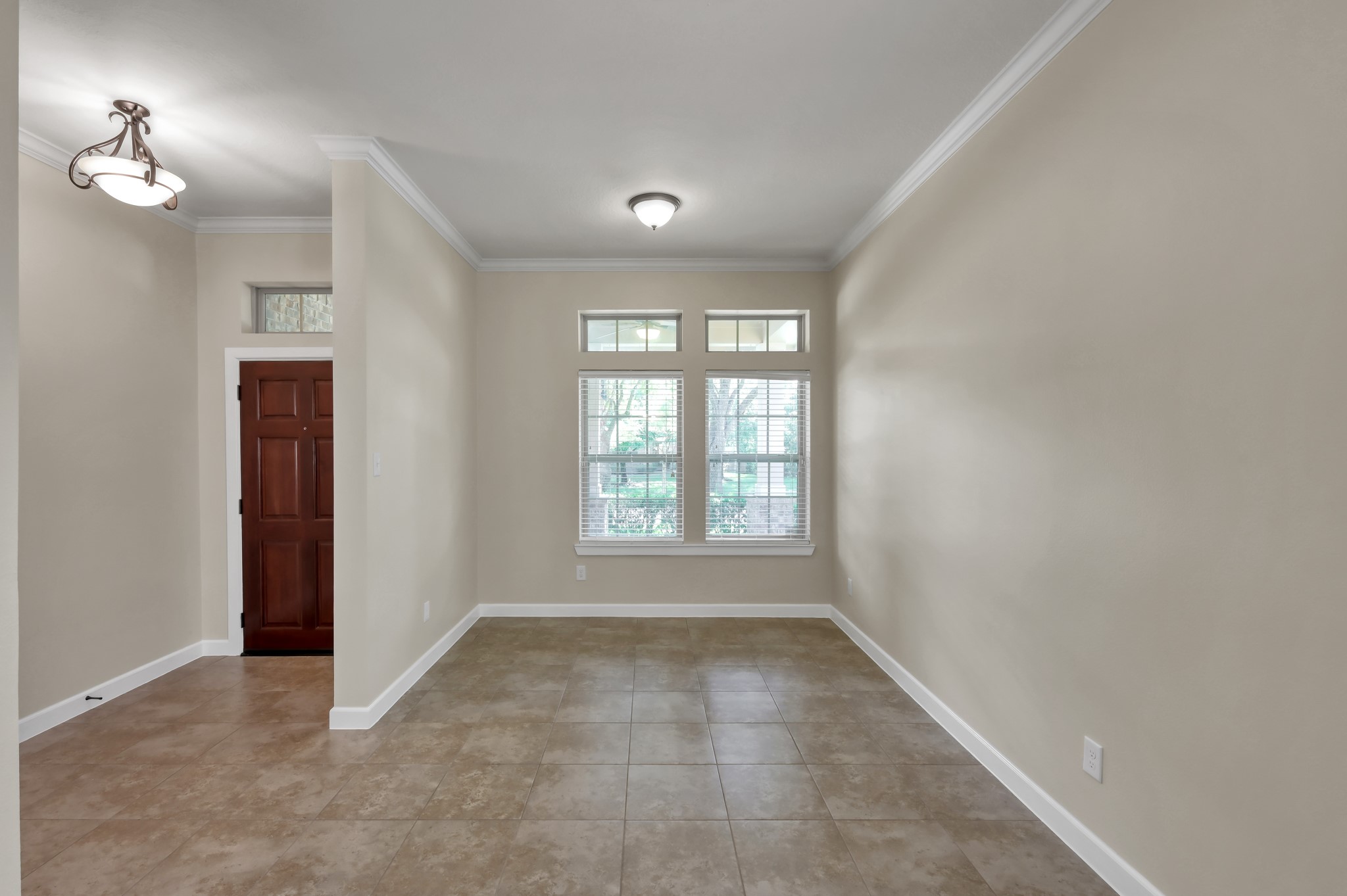 31507 Boulder Cliff Lane Spring, TX 77386 - Photo 4 of 45 This is a spacious, light-filled entryway with neutral-colored walls and tiled flooring. It features a wooden door and large windows for natural light, creating a warm and inviting atmosphere.