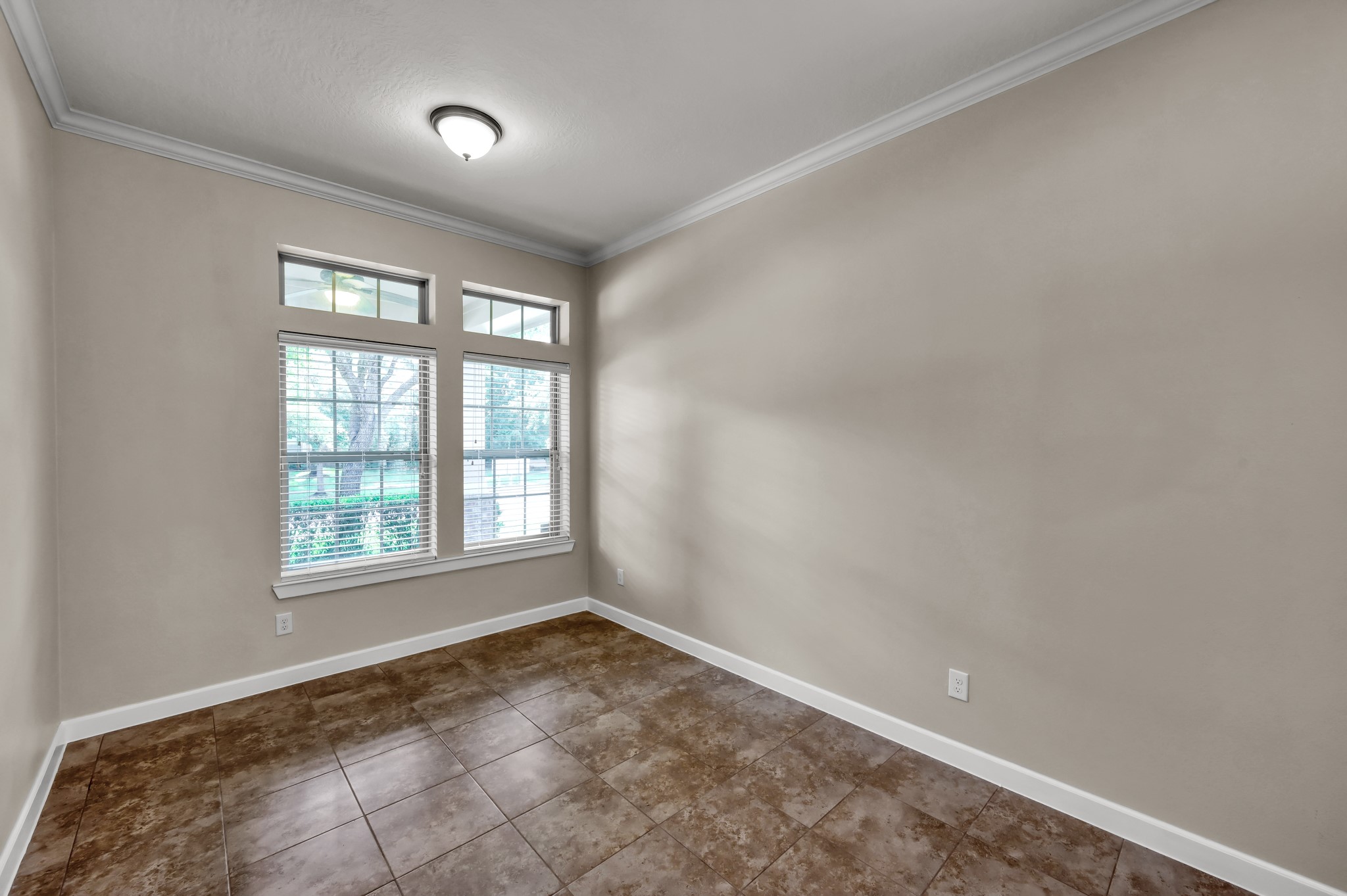 31507 Boulder Cliff Lane Spring, TX 77386 - Photo 5 of 45 This room features large windows providing ample natural light, neutral walls, and tile flooring, creating a bright and versatile space suitable for an office or sitting area.