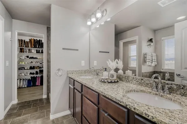a bathroom with a granite countertop double vanity sink and a mirror
