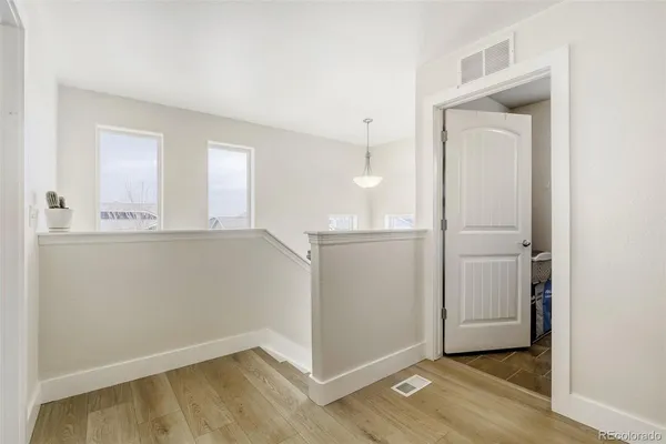 an empty room with wooden floor cabinet and door