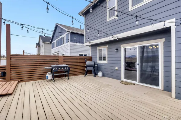 a view of a house with a barbeque and wooden stairs