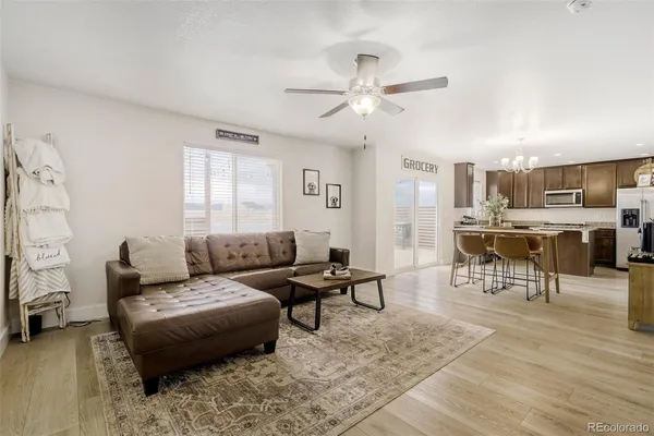 a living room with furniture and a view of kitchen