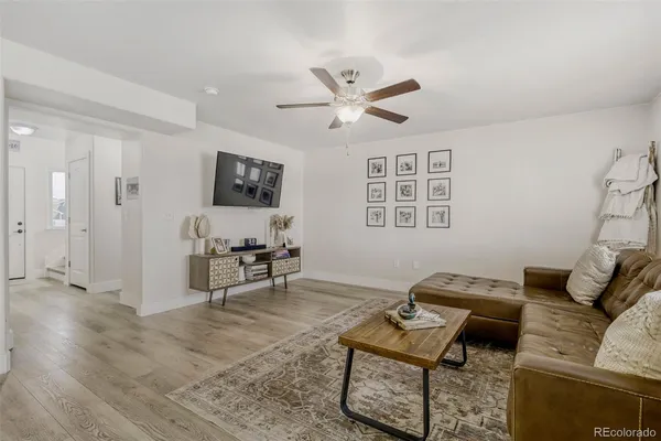 a living room with furniture and a flat screen tv with kitchen view