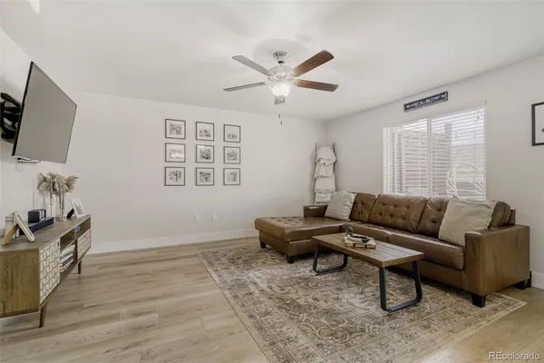 a living room with furniture a flat screen tv and a window