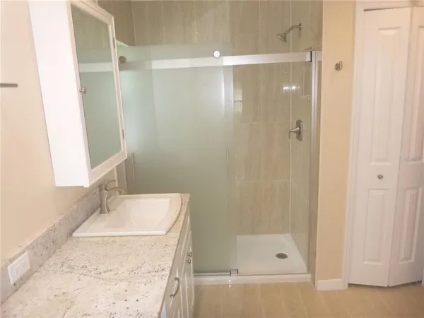 a bathroom with a granite countertop sink and white cabinets