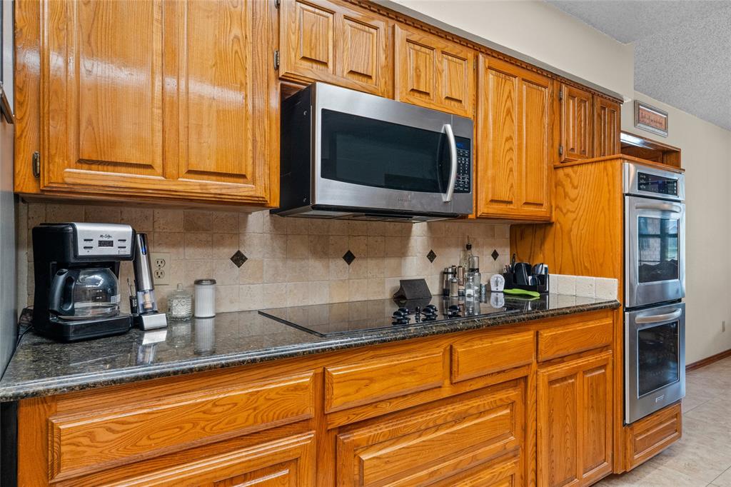 5840 Crystal Drive Midlothian, TX 76065 - Photo 10 of 36 a kitchen with stainless steel appliances granite countertop white cabinets and a microwave oven