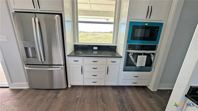 a kitchen with sink cabinets and wooden floor