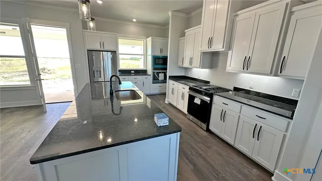 a view of a kitchen with refrigerator and window