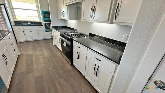 a kitchen with white cabinets and white appliances