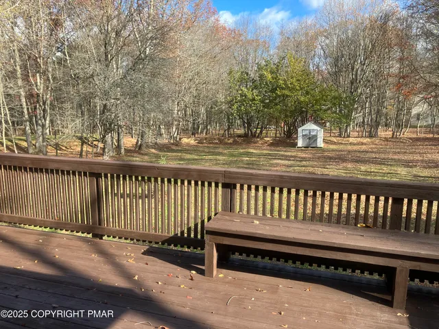 a view of a roof deck with wooden fence and trees