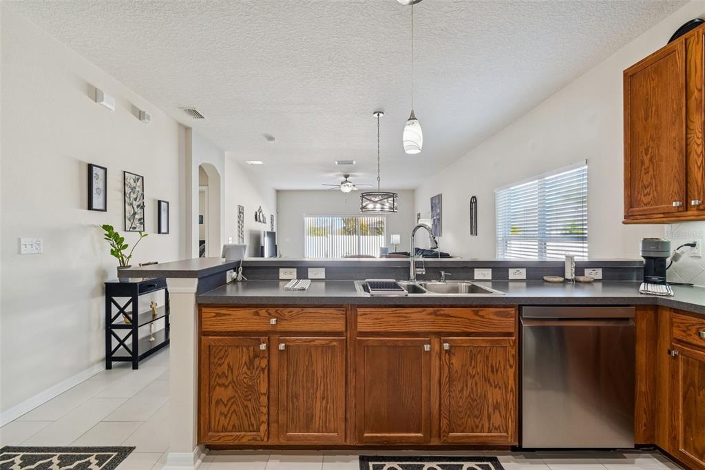 5956 Desert Peace Avenue Land O' Lakes, FL 34639 - Photo 17 of 79 a kitchen with kitchen island granite countertop a sink cabinets and stainless steel appliances