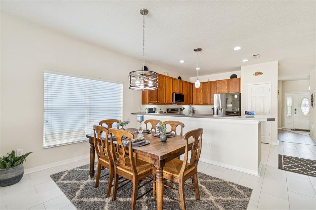 5956 Desert Peace Avenue Land O' Lakes, FL 34639 - Photo 22 of 79 a kitchen with stainless steel appliances kitchen island granite countertop a table and chairs