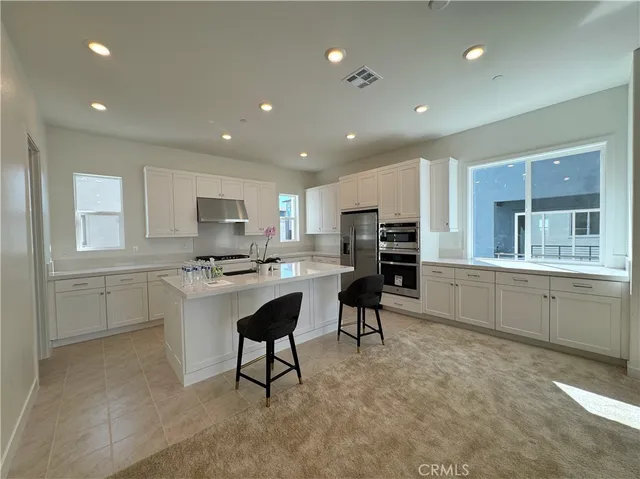 a kitchen with refrigerator and cabinets