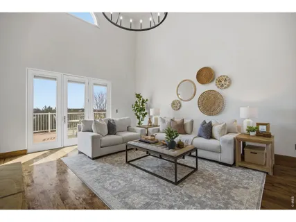 a living room with couches a dining table and a chandelier