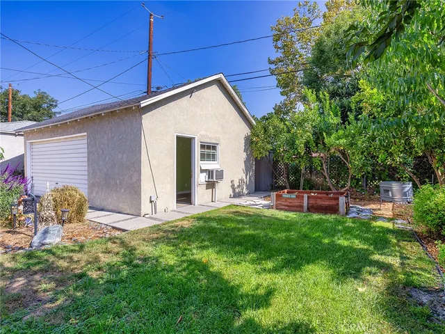 a backyard of a house with table and chairs and potted plants