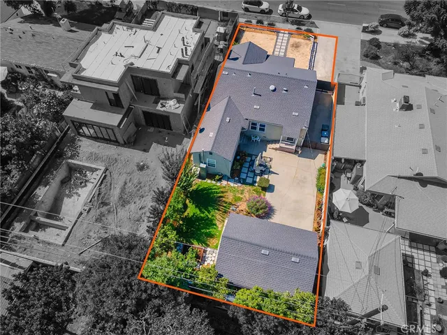 an aerial view of a houses with a lush green hillside