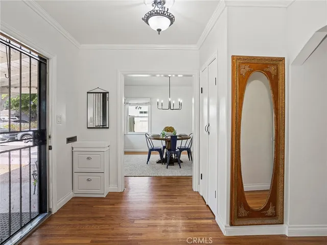 a view of a hallway with wooden floor windows and a livingroom