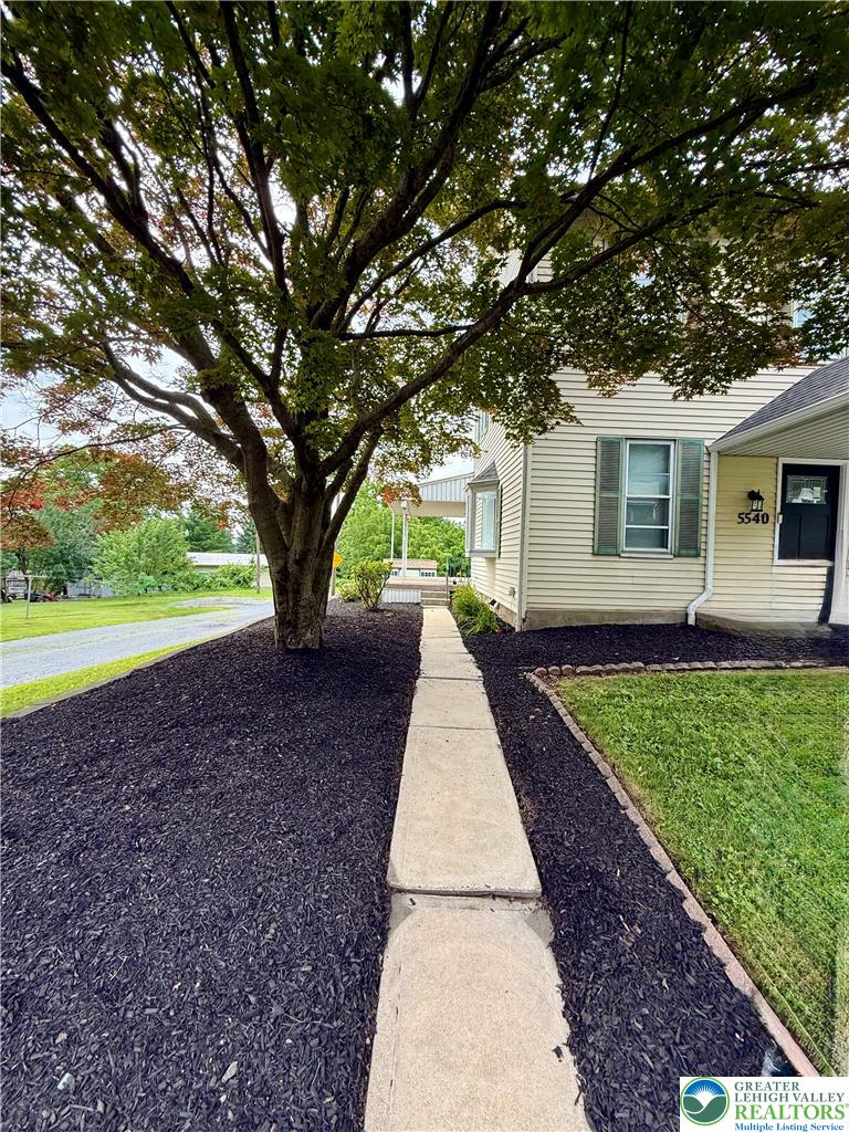 5540 Main Street Whitehall, PA 18052 - Photo 4 of 53 A welcoming walkway leads to a charming residence, surrounded by mature trees and well-maintained landscaping.