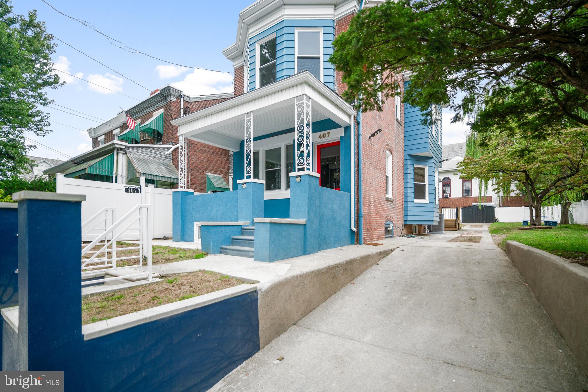 407 Sanger Street Philadelphia, PA 19120 - Photo 12 of 47 a view of a white house with large windows and a small yard