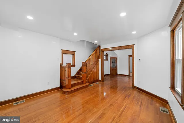 a view of a hall with wooden floor and stairs