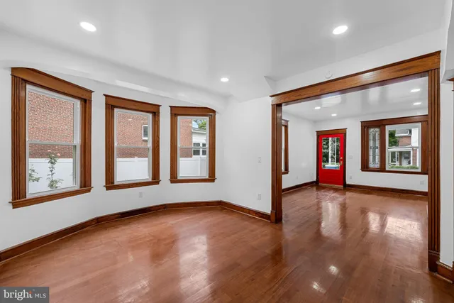 a view of an empty room with window and wooden floor