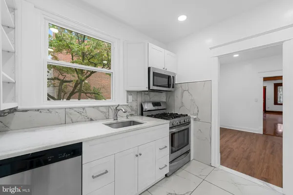 a kitchen with a sink stove and microwave