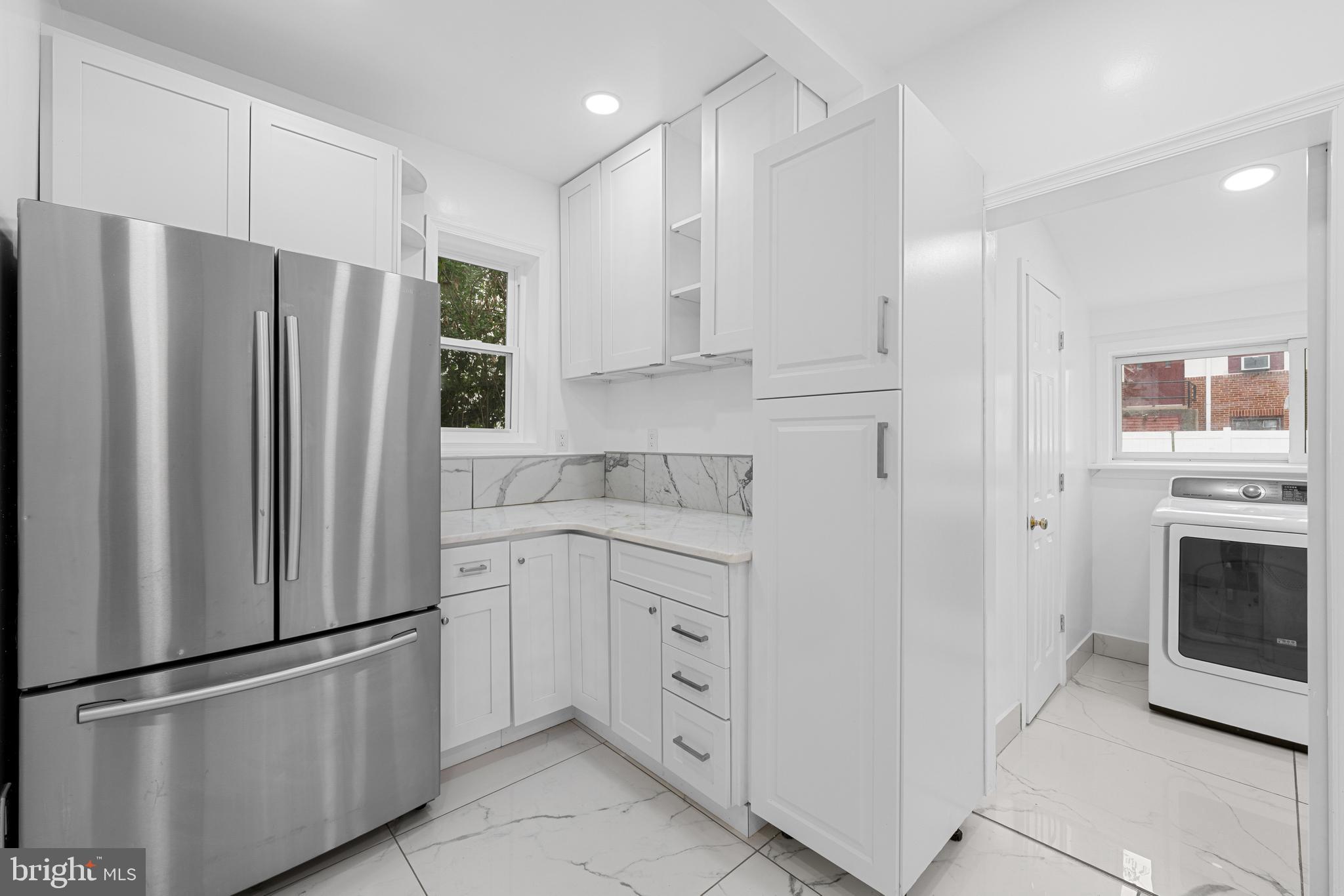 407 Sanger Street Philadelphia, PA 19120 - Photo 22 of 47 a kitchen with white cabinets and stainless steel appliances