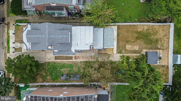 an aerial view of residential houses with outdoor space and trees